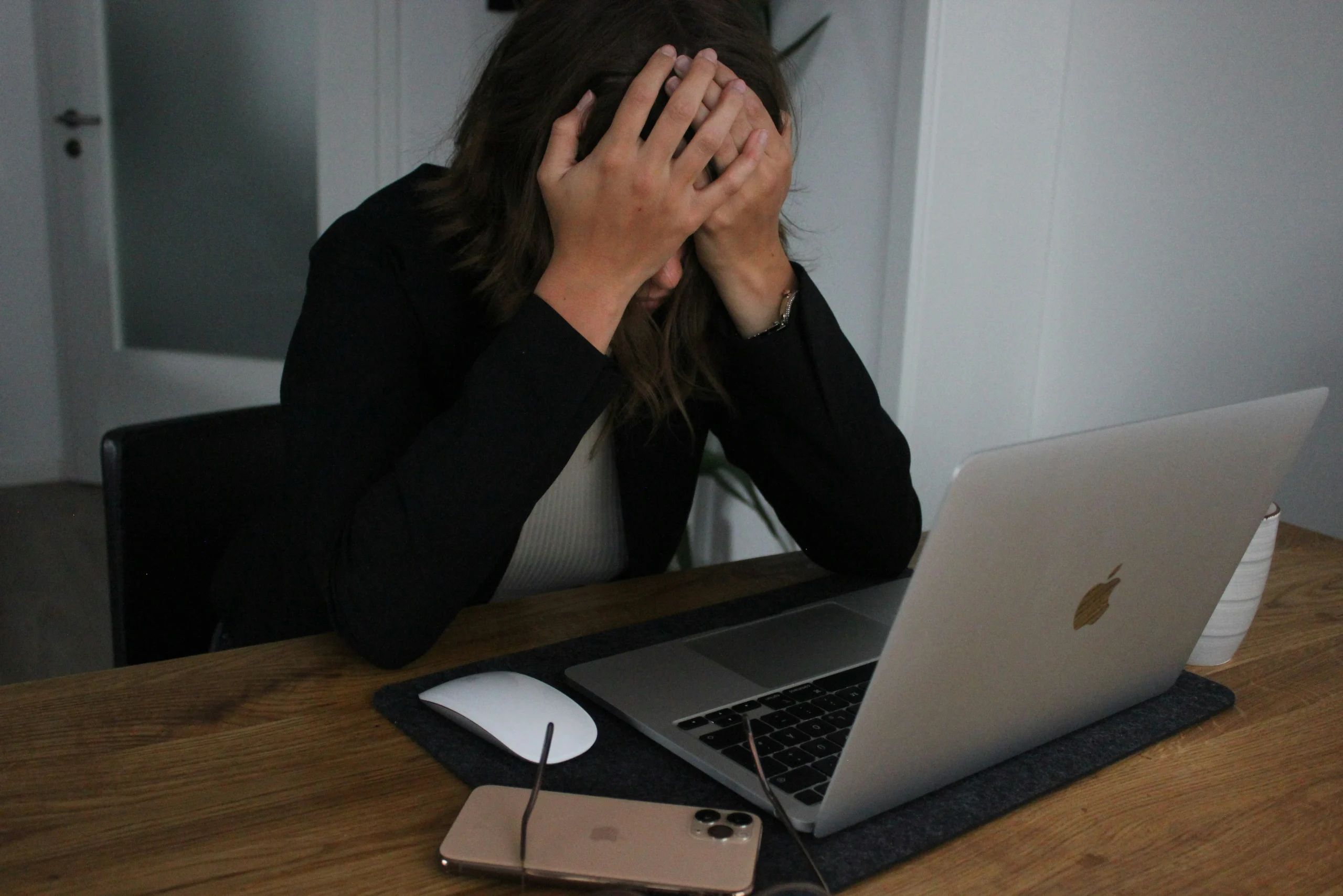 Person holding their head at a desk representing stress and anxiety support